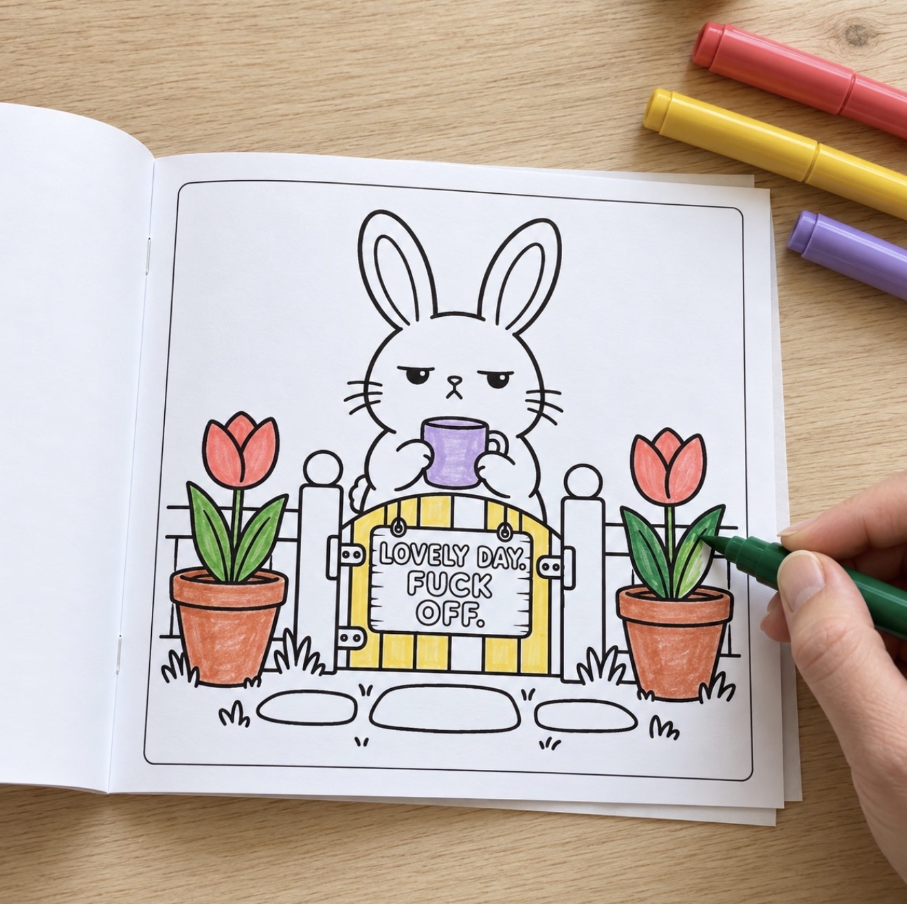 Open colouring book with a sweary bunny design being coloured